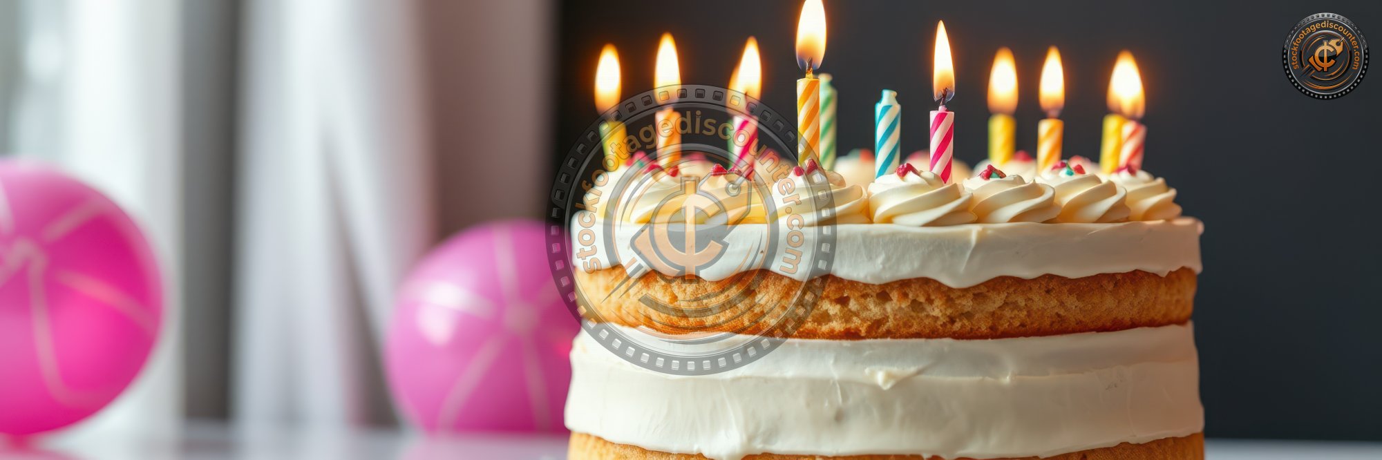 Celebrating a birthday with a beautifully decorated cake featuring candles and festive balloons in a cozy indoor setting